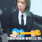 a woman with green hair is holding a toy guitar