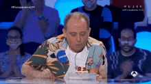 a man with the name javier on his shirt blows out candles on a birthday cake