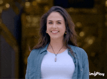 a woman in a blue shirt and white shirt is smiling with imgplay written on the bottom right corner