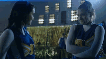 two cheerleaders standing next to each other with one wearing a jersey that says rb on it