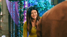 a woman in a yellow dress is smiling at a man .