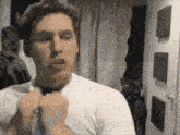 a man wearing a white shirt and a bow tie is making a funny face