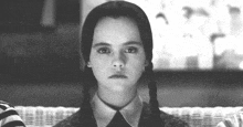a black and white photo of a girl with pigtails and a striped shirt .