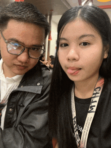 a man and a girl are posing for a picture and the girl has a lanyard that says chill on it