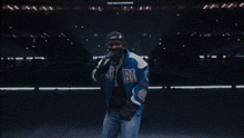 a man in a blue jacket with the letter a on the front