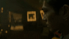 a blurry picture of a man in a dark room with a few lights behind him