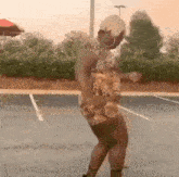 a woman is dancing in a parking lot in a leopard print dress .