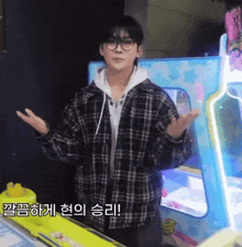 a man wearing glasses and a plaid jacket is standing in front of a machine with chinese writing on it