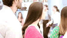 a man and woman are standing next to each other in a crowded room .
