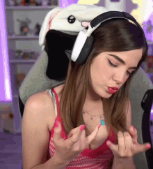 a woman wearing headphones and a bunny hat looks at her nails