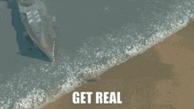 an aerial view of a boat on the beach with the words get real below it