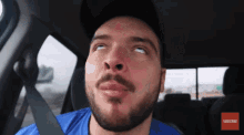 a man with a beard is sitting in a car with a subscribe button