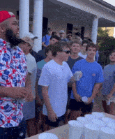 a man wearing a budweiser shirt stands in a crowd