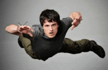a man in a gray shirt is flying through the air