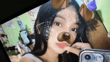 a girl is taking a selfie with a dog face mask on her face .
