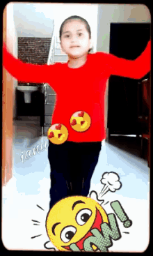a girl in a red shirt is standing next to a cartoon smiley face that says wow