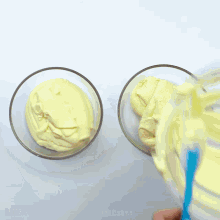 a person pouring chocolate into two bowls of cream