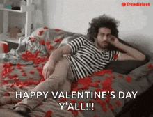 a man is laying on a bed covered in rose petals and says happy valentine 's day y 'all !
