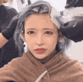 a woman with a piercing in her lip has her hair dyed
