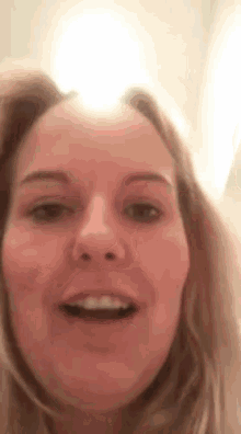 a close up of a woman 's face with her mouth open and a light shining on her face .