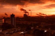 a sunset over a city with smoke coming out of the chimneys and a building that says ed crystal