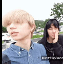 two young men are standing next to each other and one of them is wearing a black hoodie