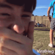 a person covering their mouth with their hand with the words viralhog written on the bottom right