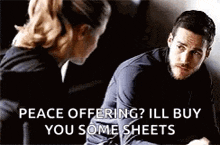 a man and a woman are sitting next to each other and the man is asking the woman if she wants to buy some sheets .