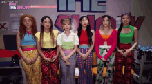 a group of girls pose for a photo in front of a sign that says the show