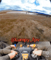a person is holding a remote control with the words @lumpy_fpv written on it