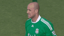 a man in a green reina jersey stands in front of a soccer goal