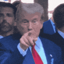 a man in a suit and tie is pointing at something