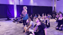 a woman stands in front of a group of people