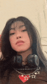 a woman wearing headphones and a necklace with stars on it