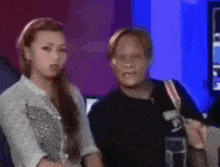 a blurry picture of two women standing next to each other .