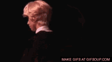 a boy in a wig is hugging a girl in a black suit .