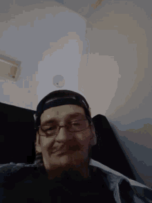 a man wearing glasses and headphones looks down at the camera