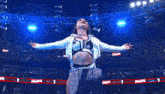 a female wrestler stands in front of a crowd in a stadium that says raw