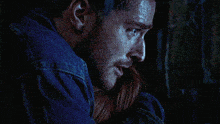 a man in a blue shirt is hugging a woman