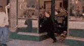 a man in a black coat is walking out of a store with a sign that says choice .