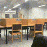 a blurred image of a library with tables and chairs and a sign that says exit