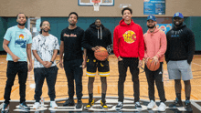 a group of men standing on a basketball court with one wearing a hoodie that says dirty birds