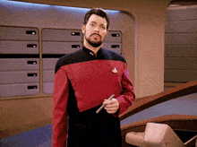 a man in a star trek uniform is holding a pen in his hand