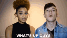 a man and a woman are standing next to each other and the words what 's up guys are visible
