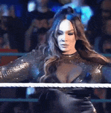 a woman in a black dress is in a boxing ring