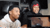 two young men are sitting in front of a screen that says justzik