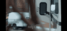 a white van is parked next to a rv with the words holy crap written on it