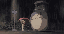 a little girl holding an umbrella stands next to a totoro holding an umbrella