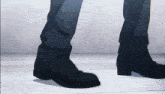 a close up of a person 's feet in black boots