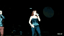a man and a woman singing on a stage with rbd.gif in the bottom right corner